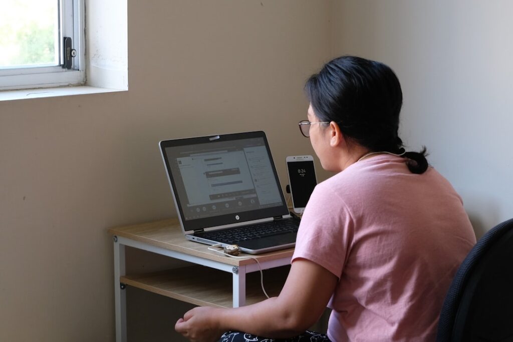 Woman working on laptop computer analyzing SEO tools and research at home