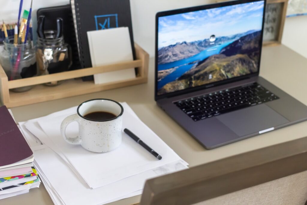 Clean and organized workspace with laptop, coffee cup, and notebook representing productive content creation workflow