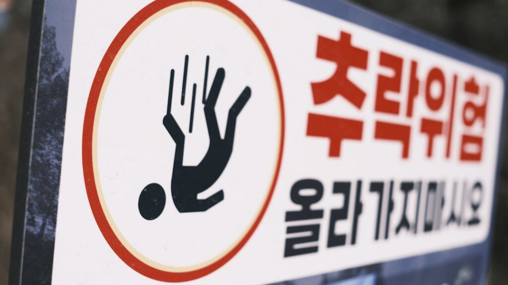 Warning sign with falling person icon representing SEO pitfalls and mistakes to avoid in programmatic content creation