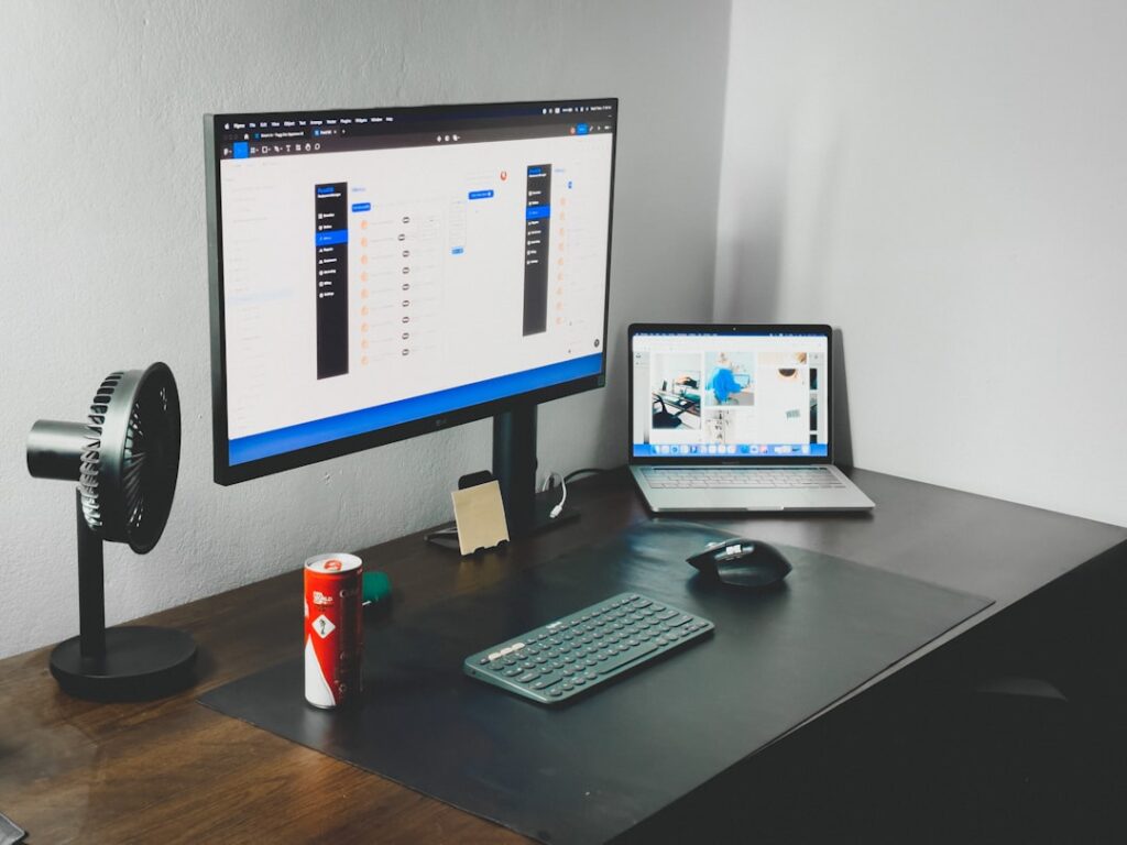 Clean workspace with dual monitors displaying analytics dashboards and SEO tools for competitor research