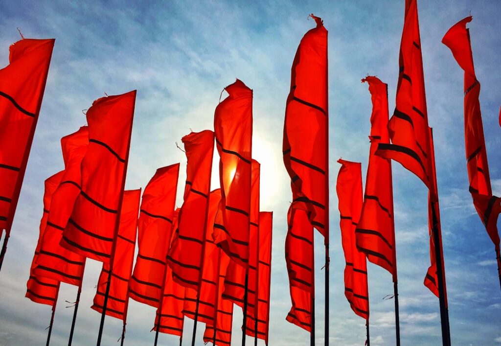 Red flags waving in the wind, symbolizing warning signs in business relationships