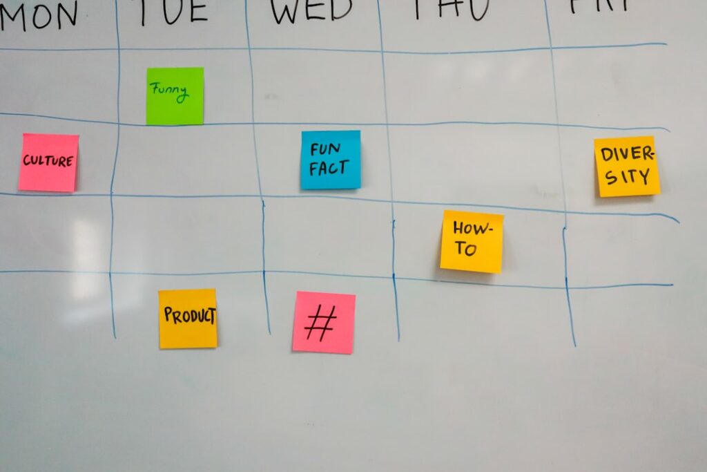 Content planning on a white board with colorful sticky notes organized by days of the week