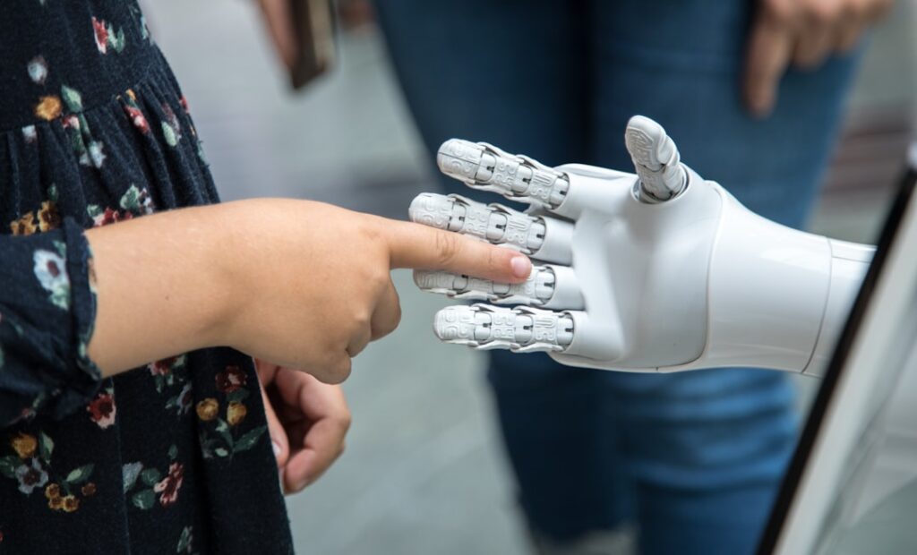 Human hand interacting with robotic hand representing AI and human collaboration in content creation