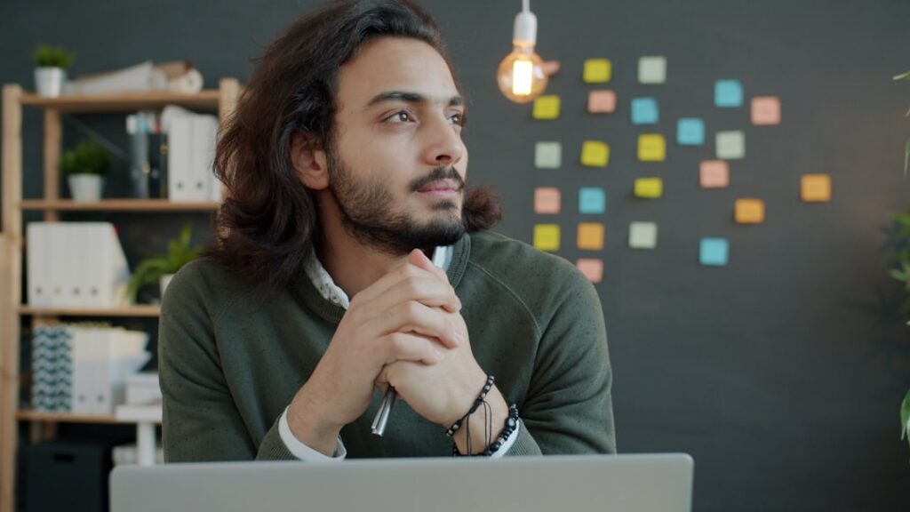 Professional businessman thinking strategically while working at computer, representing human expertise in SEO decision making