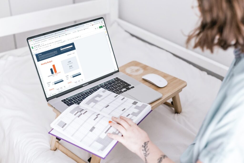 Person reviewing software pricing dashboard on a laptop with a planning notebook open, comparing subscription costs