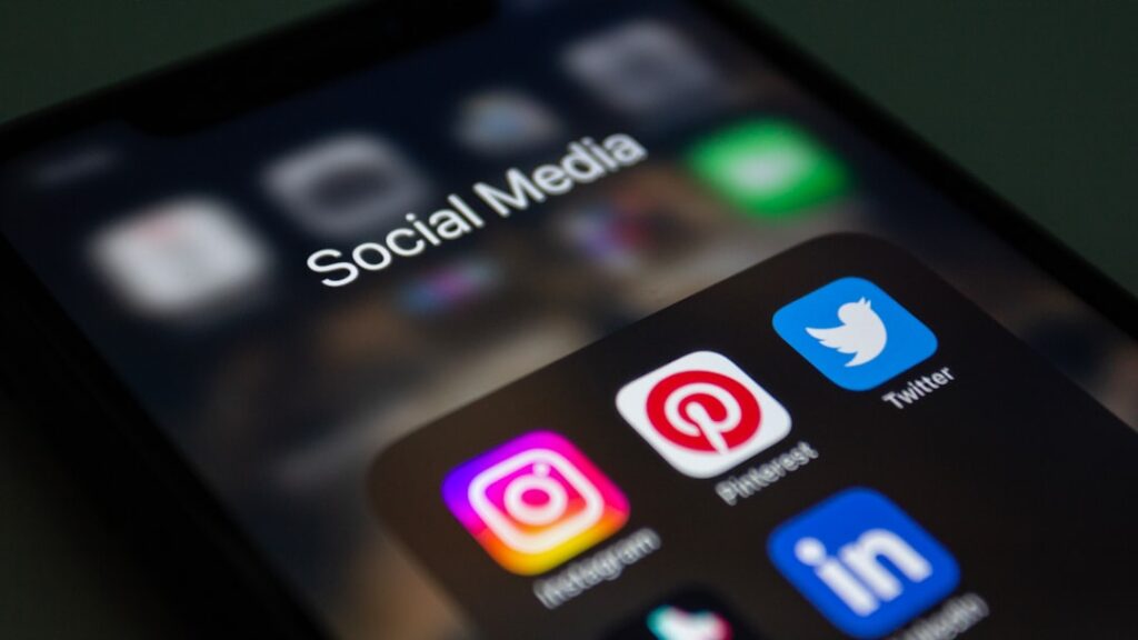 Smartphone screen showing social media app icons including Instagram, Pinterest, Twitter, and LinkedIn.