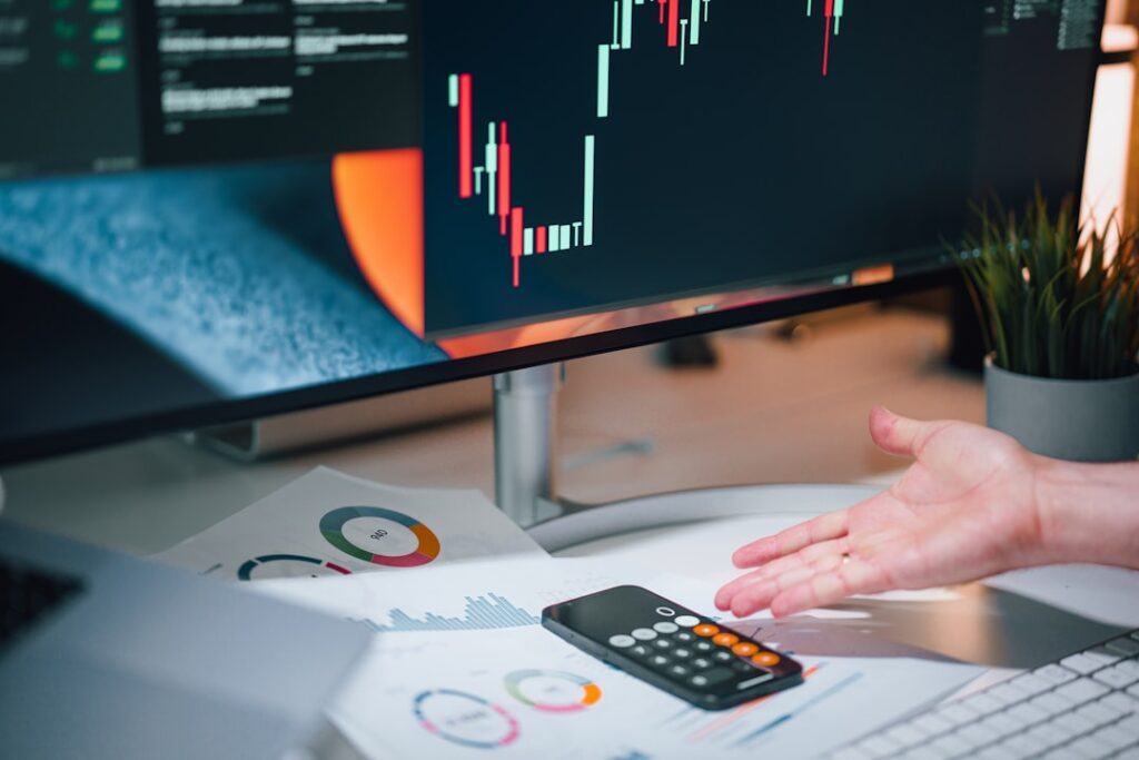 Business professional analyzing growth metrics and charts on computer screen with calculator, representing measurement of AI search optimization success