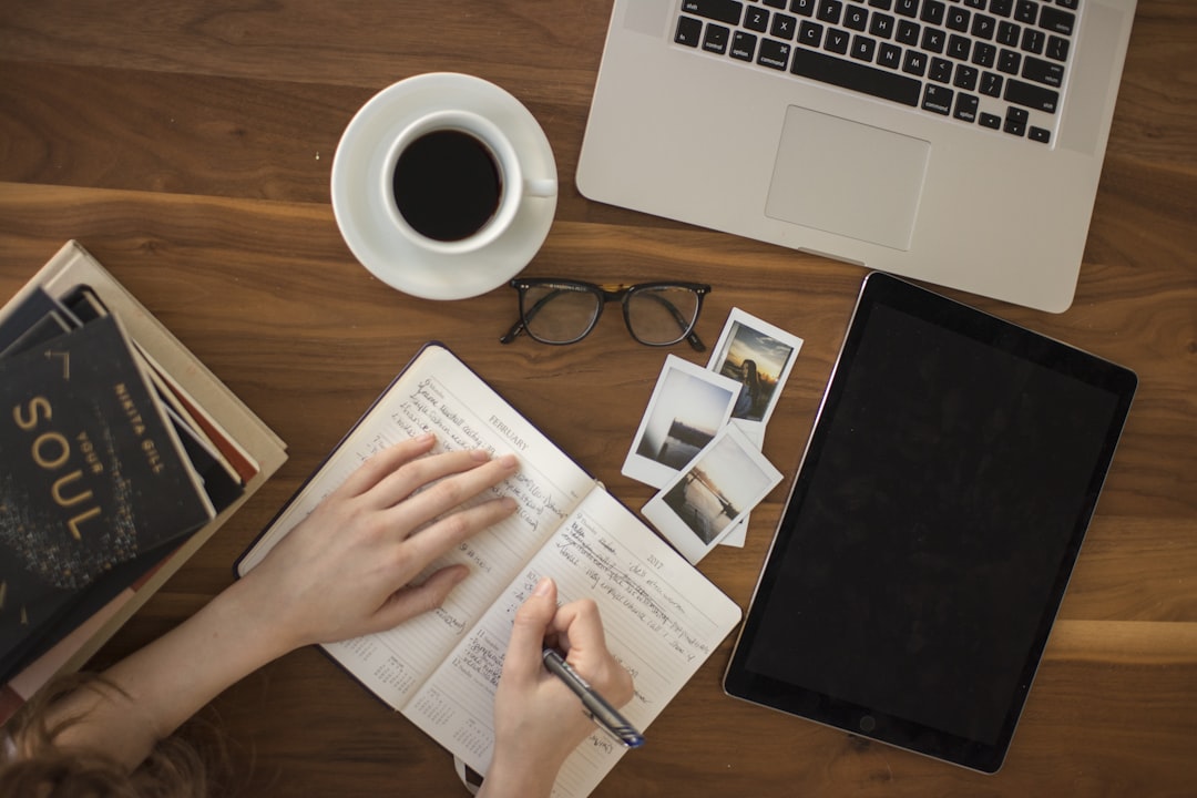 Laptop and notebook on desk for comparing AI blogging tools — ClearPost vs BotWriter