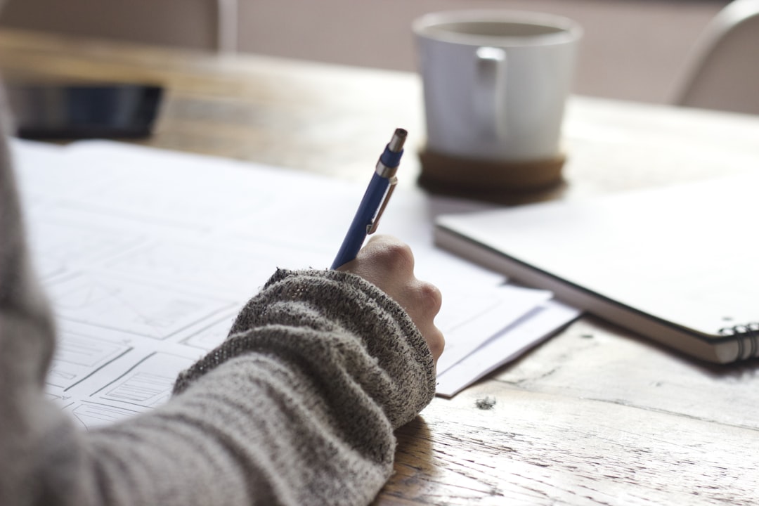 Person writing notes while researching content tools — ClearPost vs Content Pilot