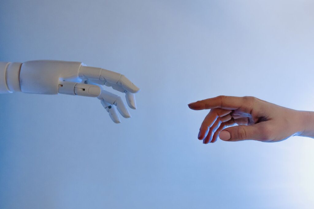A human hand and a robotic hand reaching toward each other, symbolizing AI and human collaboration in content creation