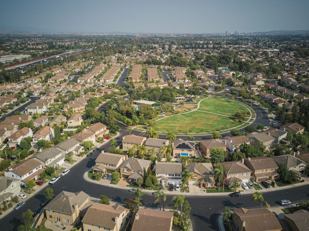 Aerial drone view of a suburban neighborhood with houses and a central park