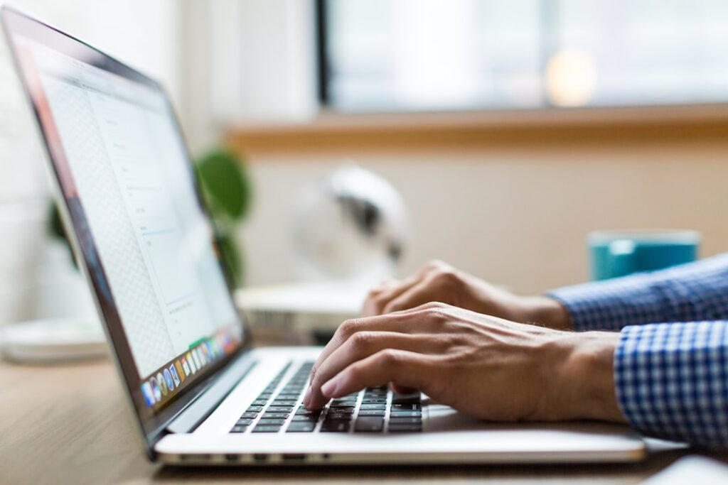 Person typing on a laptop reviewing and editing blog content before publishing, representing the human approval step in AI content workflows