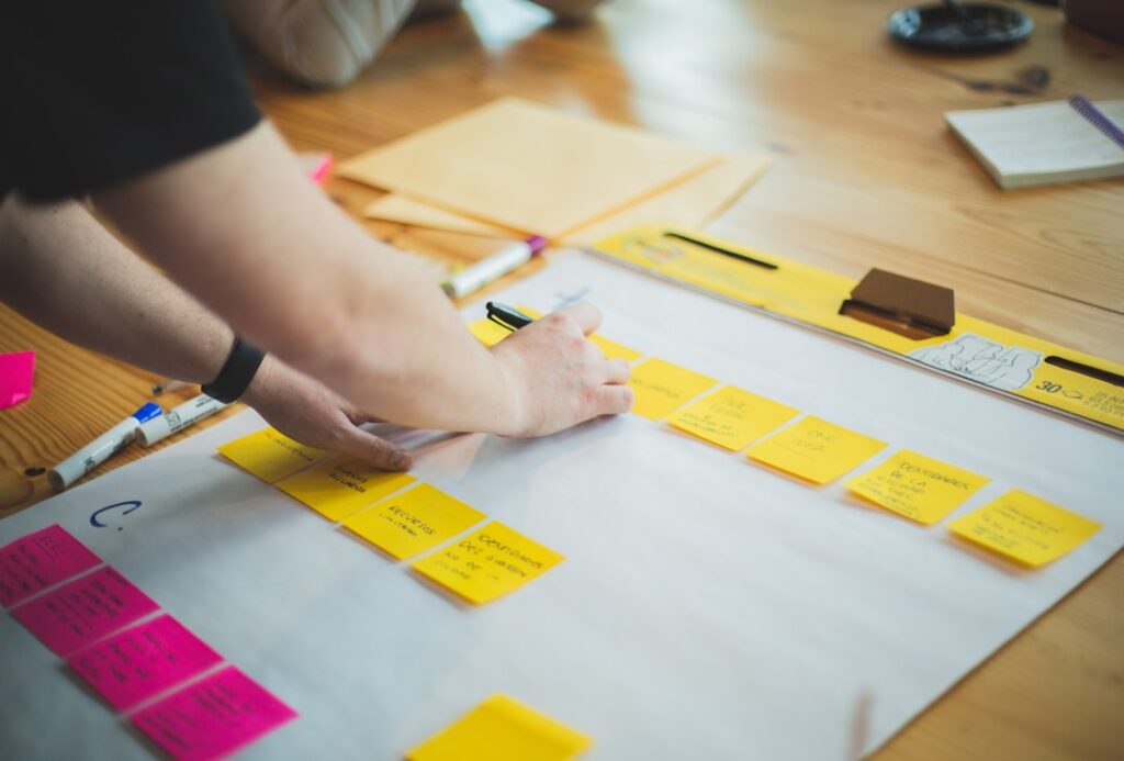 Person mapping out a content strategy using sticky notes on a large sheet of paper