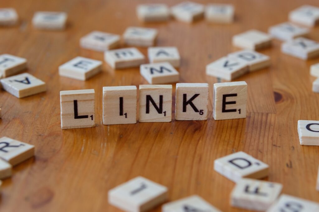 Scrabble tiles spelling LINK on a wooden table, representing internal linking strategy