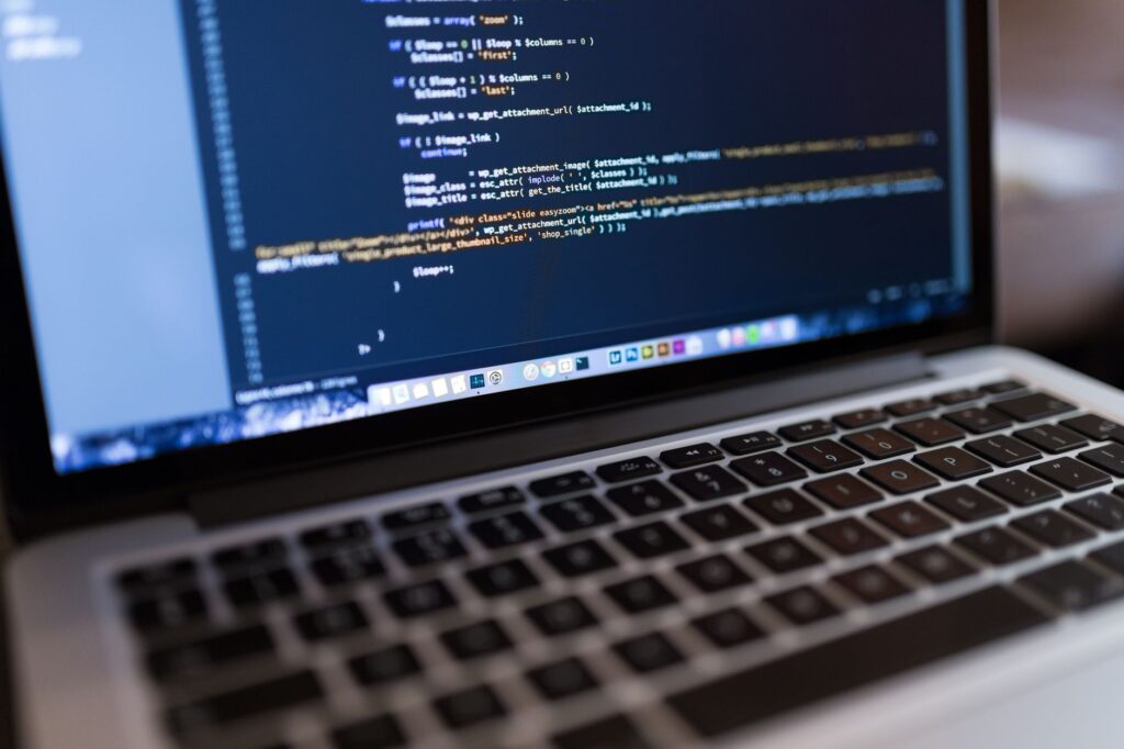 Laptop screen showing WordPress or PHP code, representing editing wp-config.php to set the DISABLE_WP_CRON constant