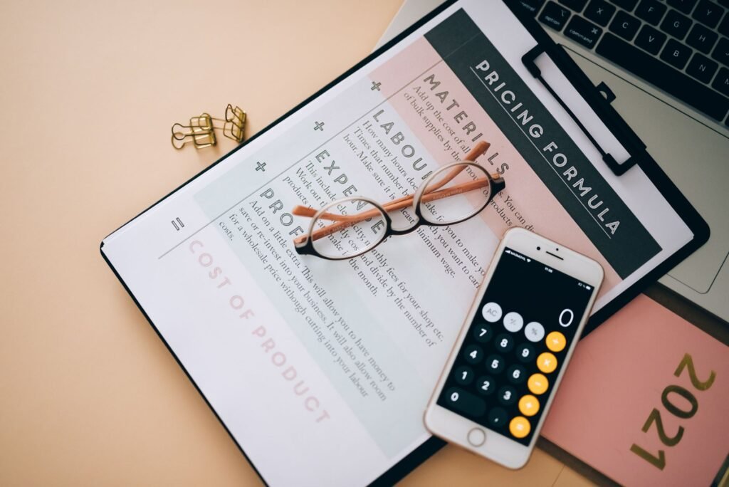 Pricing formula document with calculator and glasses on a desk, illustrating Frase plan cost comparison