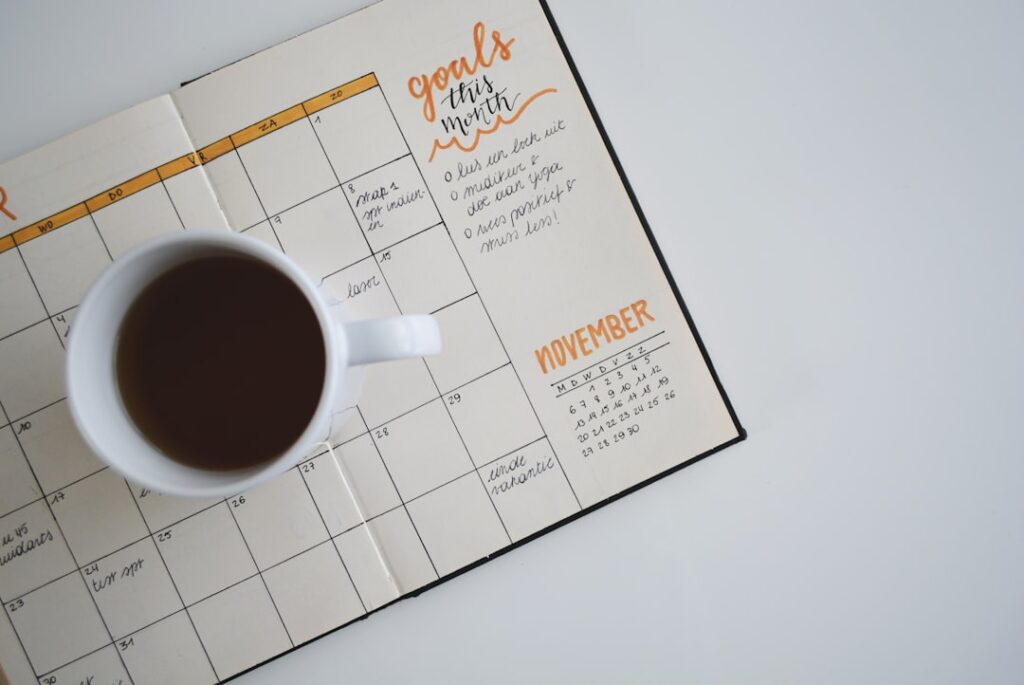 Monthly planning calendar with goals and coffee mug representing content scheduling and publishing automation