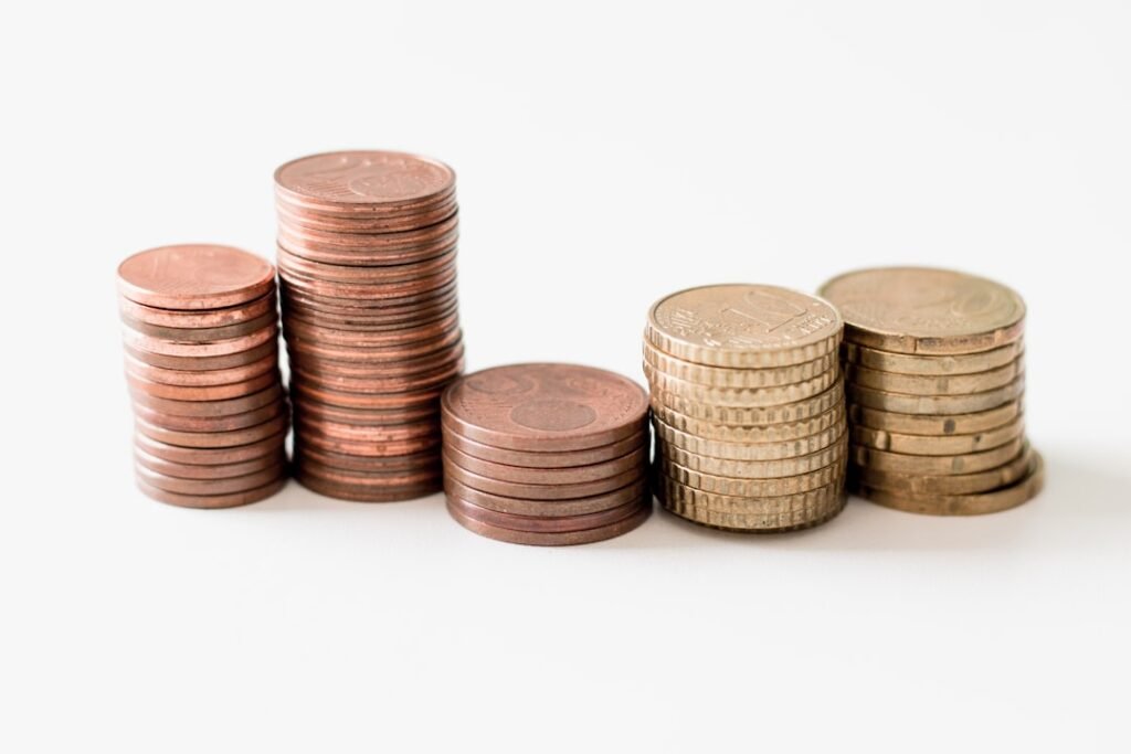 Small stacks of coins representing the limited value and tiny allowances of restrictive free tier AI writing plans
