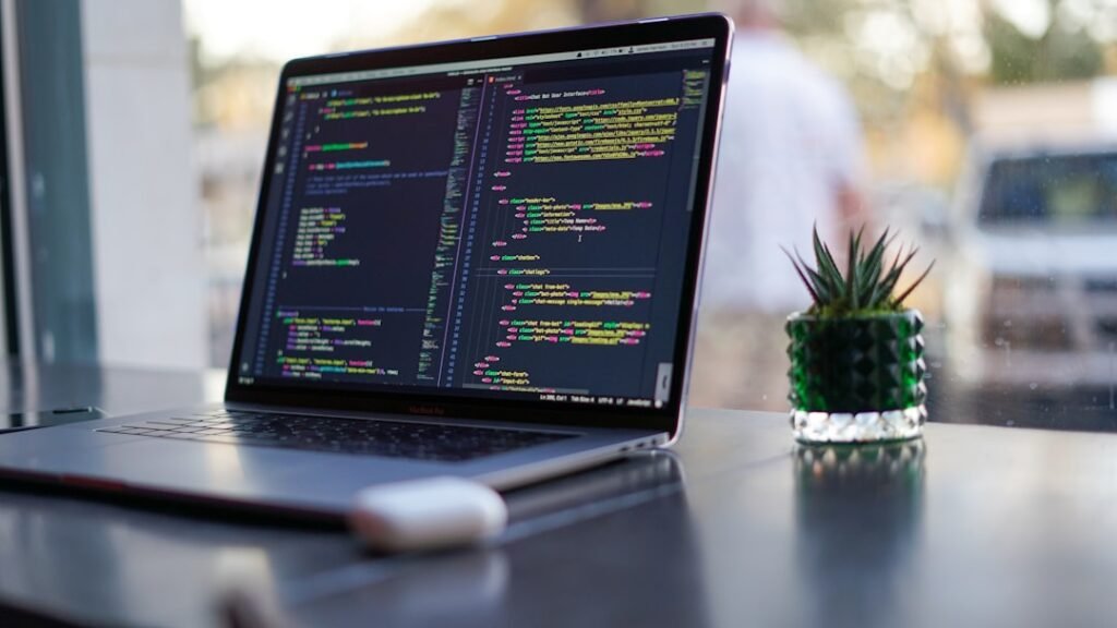 Laptop showing colorful code in a code editor, representing API key setup for BYOK AI writing plugins