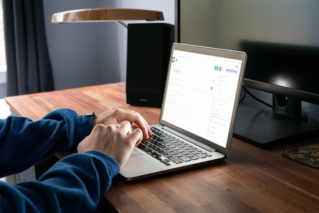 Person typing a new WordPress blog post on a MacBook, representing the manual content workflow that AI writing tools are beginning to replace