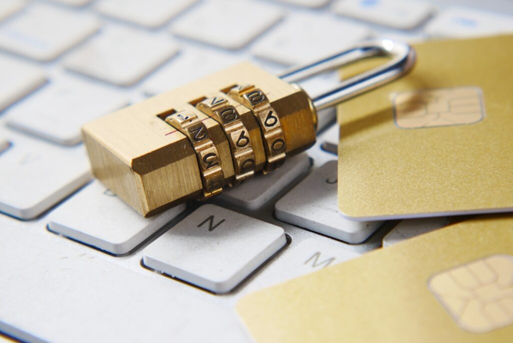 A combination padlock resting on a keyboard next to credit cards, representing HTTPS SSL security requirements for WordPress Application Passwords.