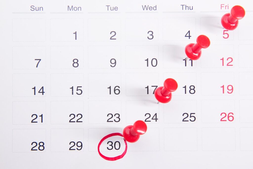 Calendar with red pins marking renewal dates, representing annual subscription pricing cycles