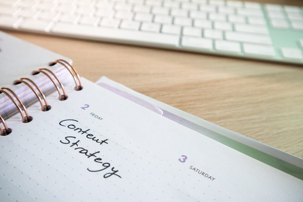 Content strategy planner notebook on a desk next to a keyboard, representing content planning and tool comparison