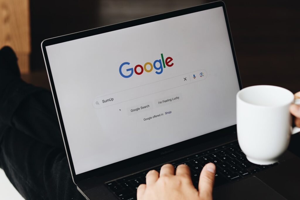 Person searching on Google using a laptop, representing SEO plugin comparison research