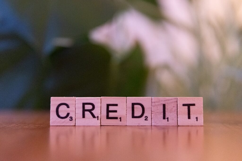 Scrabble tiles spelling the word CREDIT on a wooden surface, representing ContentBot's word-credit system.