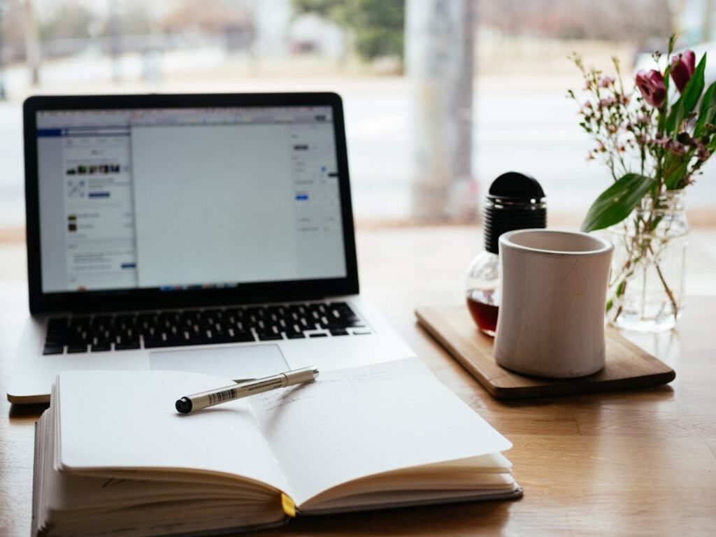 Freelance writer working independently at a desk with laptop and open notepad