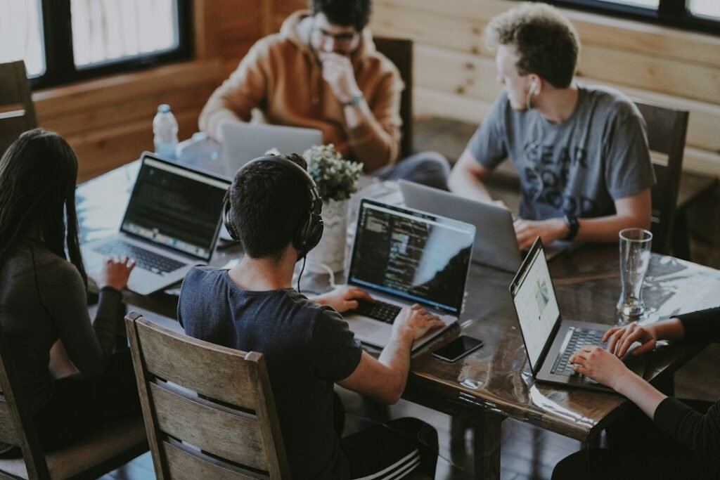 Small marketing team working on laptops at a shared table, illustrating the multi-seat cost reality of SaaS tools like Semrush