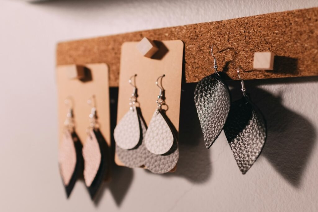 Handmade leather earrings displayed on a cork board strip, typical of Etsy handmade product listings