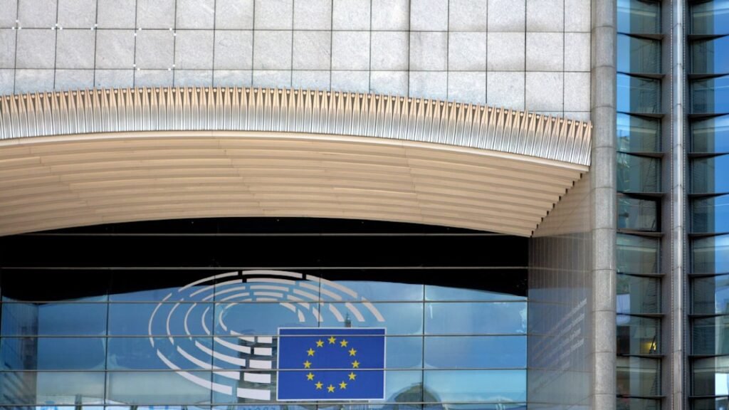 The European Parliament building in Brussels with the EU flag, representing the EU AI Act regulatory framework