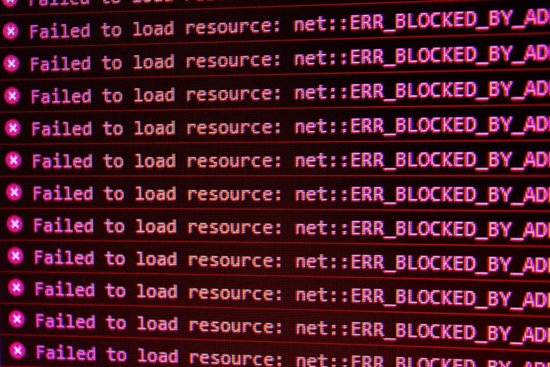 Red network error messages on a black screen showing blocked resources, illustrating cURL error 28 connection timeout failures. Photo by Unsplash.