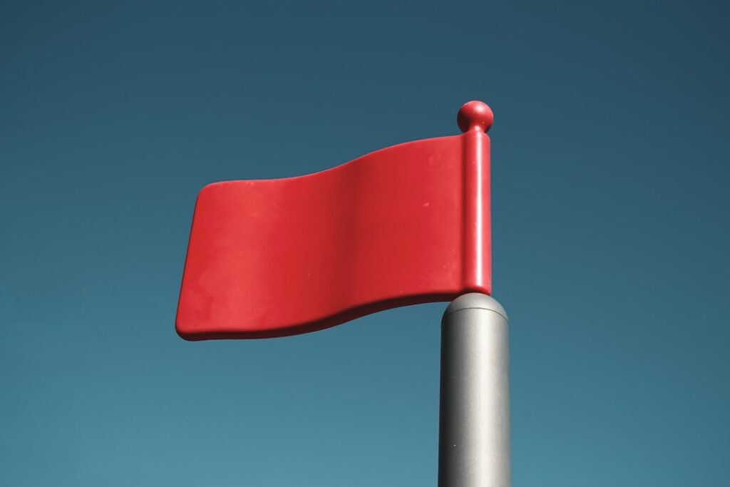 Red flag on pole against blue sky, symbolizing SEO agency red flags to watch for