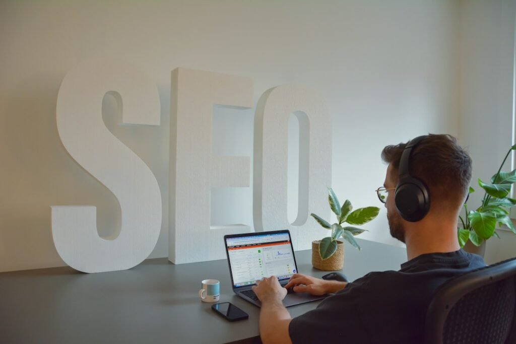 SEO professional working at desk with large SEO letters in the background, reviewing tool options