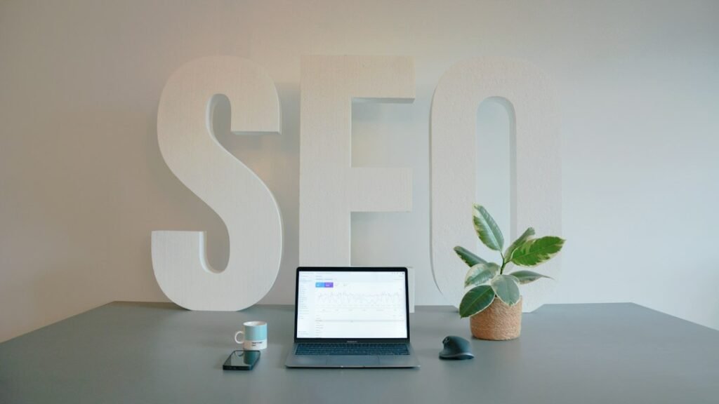 SEO agency workspace with large SEO letters and a laptop on a clean desk