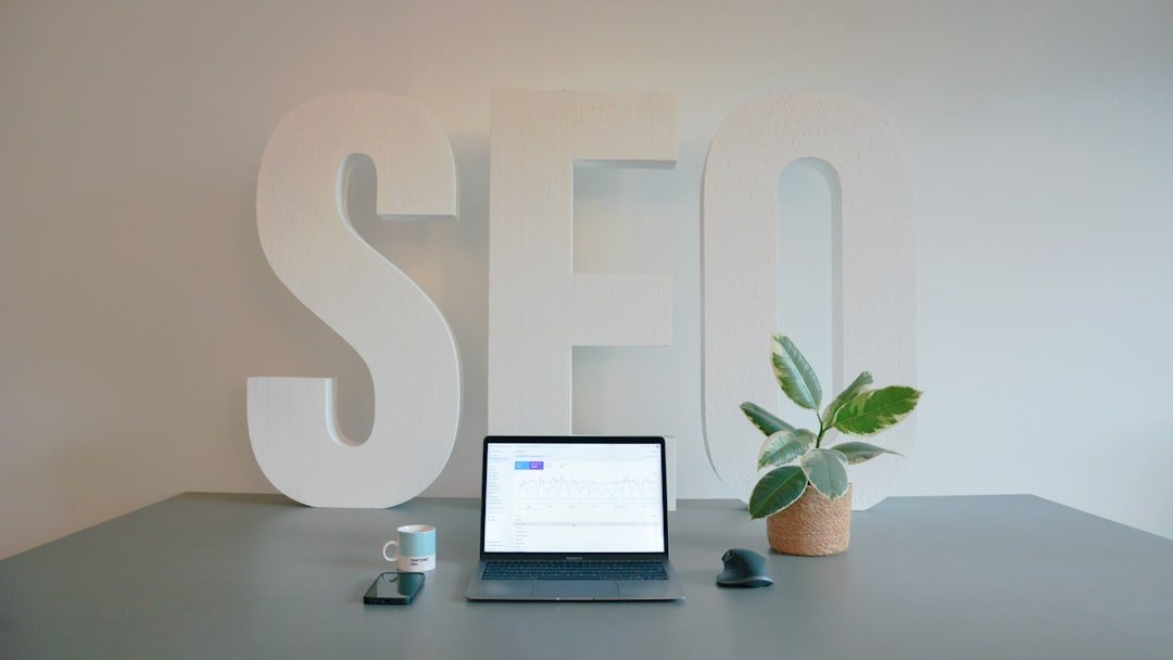 SEO workspace with large SEO letters on wall, laptop, and coffee — illustrating the challenge of managing SEO plugin settings on WordPress