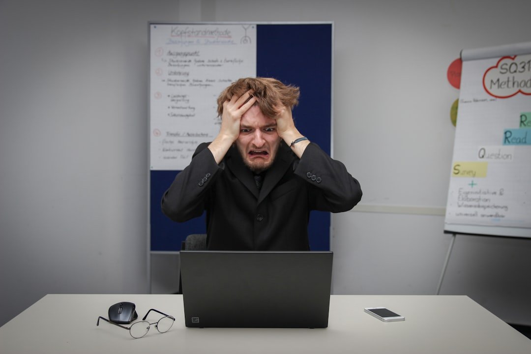Frustrated small business owner sitting at laptop overwhelmed by marketing costs