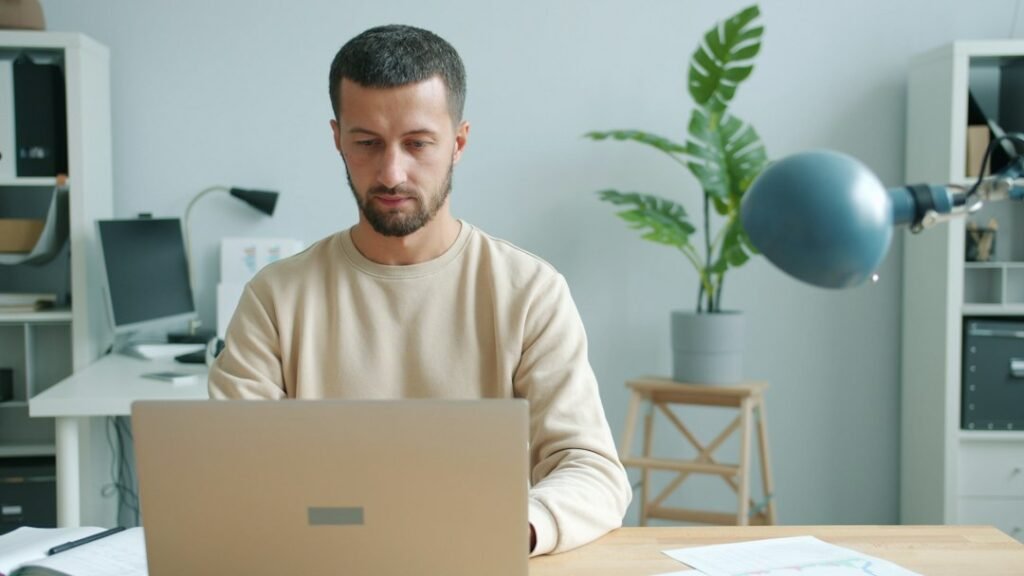 A focused business professional typing on a laptop at a clean desk, representing a small business owner managing an automated content pipeline