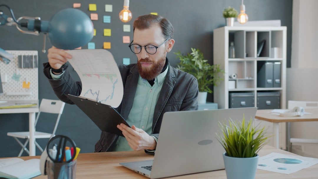 Business owner reviewing SEO analytics charts and reports at desk with laptop — photo by Unsplash