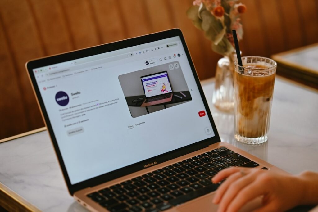 A solo marketer drafting blog content on a laptop at a cafe workspace