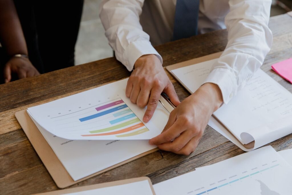 Two people reviewing a colorful scoring chart on paper, illustrating a keyword winnability scoring framework.