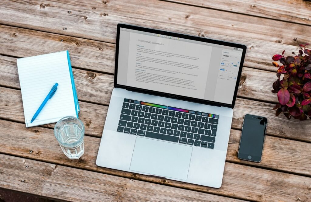 Laptop with document open on wooden desk representing WordPress content approval workflow for AI-generated local SEO pages
