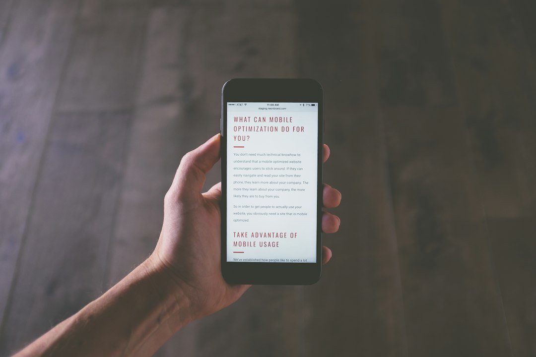 Hand holding a smartphone displaying a mobile optimization webpage, representing mobile-first SEO