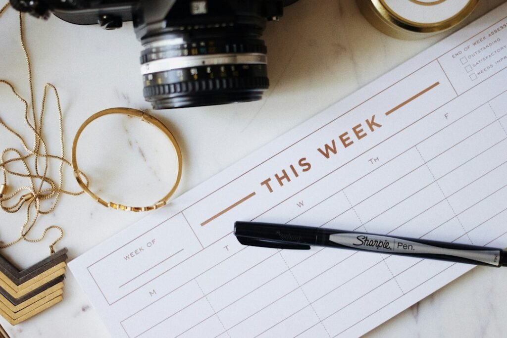 This week planner pad with a pen on a marble surface representing a weekly decision-making framework for SEO tool selection by site size