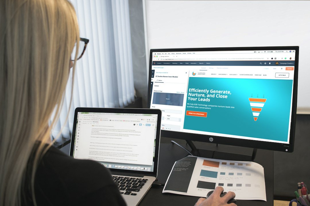 Marketing manager working at dual screens reviewing digital marketing content tools and analytics dashboards