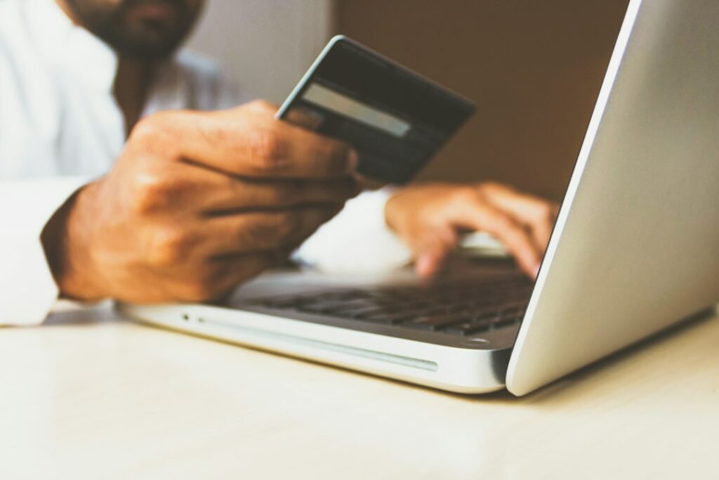 Person holding a credit card while using a laptop, representing the decision to commit to an annual billing subscription