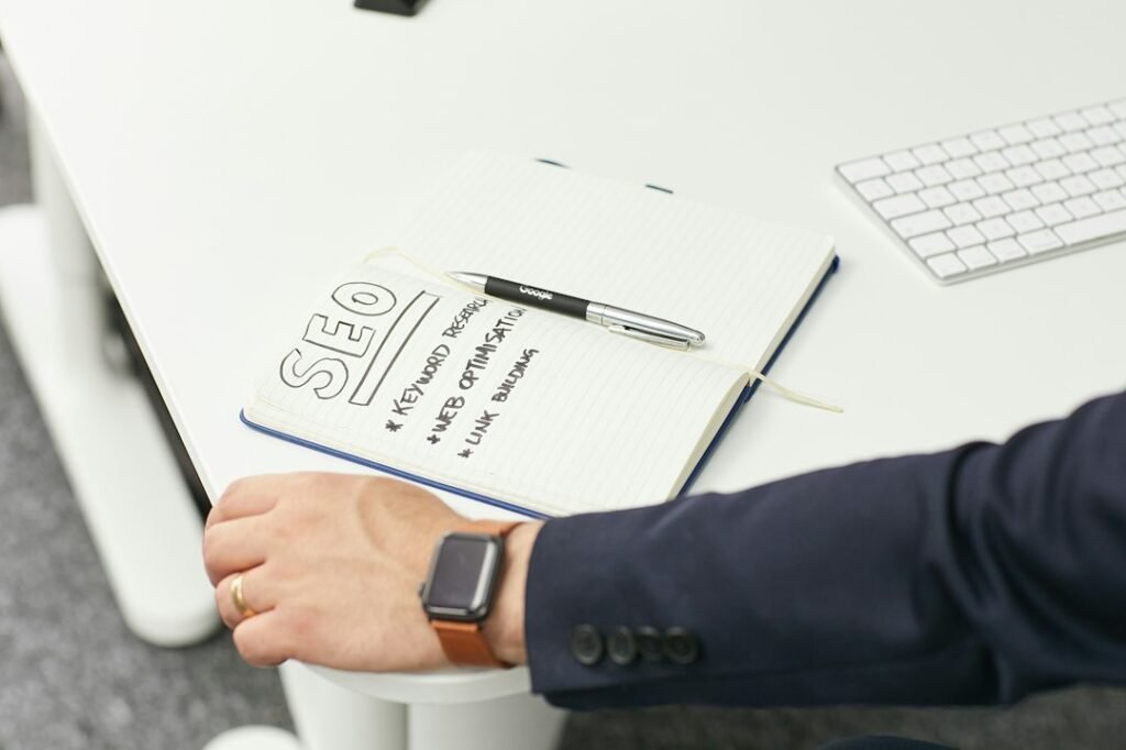 SEO keyword research notes written on a notepad alongside a keyboard, planning a step-by-step workflow