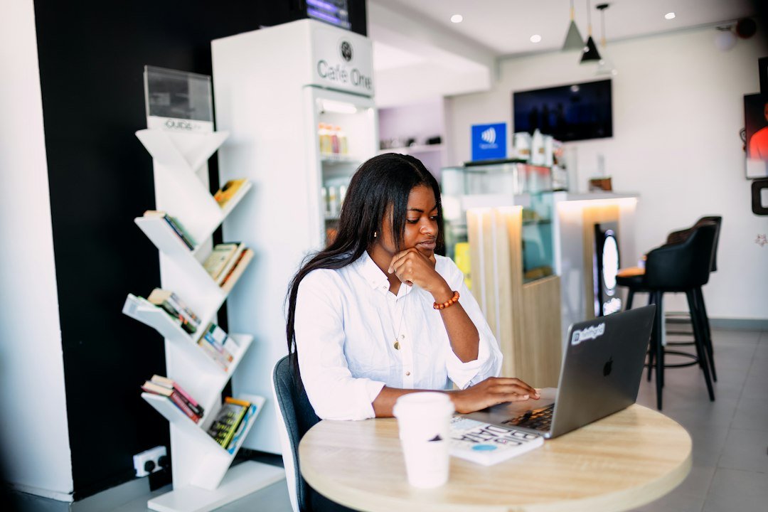 Small business owner working on laptop managing multiple location SEO strategy. Photo by Ninthgrid on Unsplash.